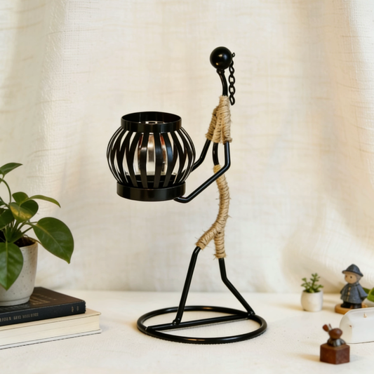 Rope wrapped candle holder with green plants and books on table