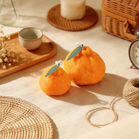 Orange candles displayed with rattan tray, dried flowers and vintage decor