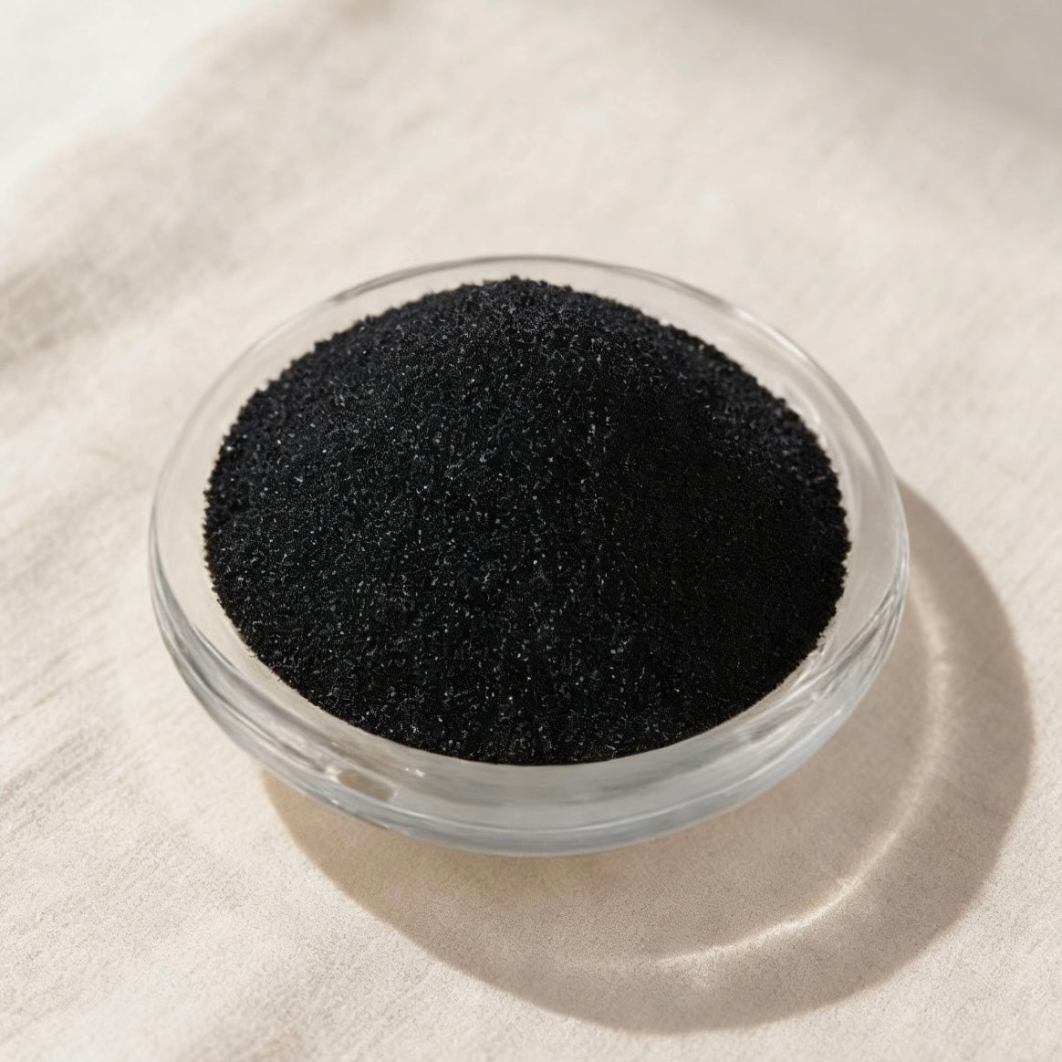 Fine black candle color powder in a clear glass dish, ideal for dyeing soy wax, paraffin wax, and gel candles to create deep, matte black finishes for DIY candle making