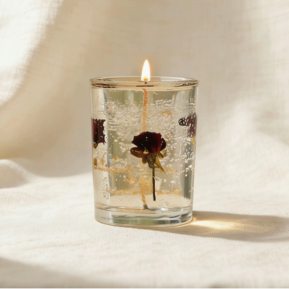 Clear gel candle with dried red rose petals, lit candle in glass jar