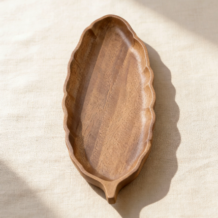 Leaf-shaped wooden tray with natural wood grain, perfect for holding candles, snacks, or small decor items as a nature-inspired home accent