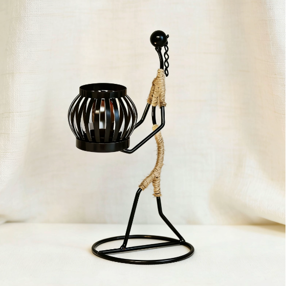 Black metal candle holder with jute rope, kneeling abstract figure
