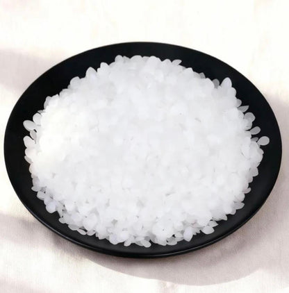White translucent pellet wax in a black bowl, ideal for candle-making supplies